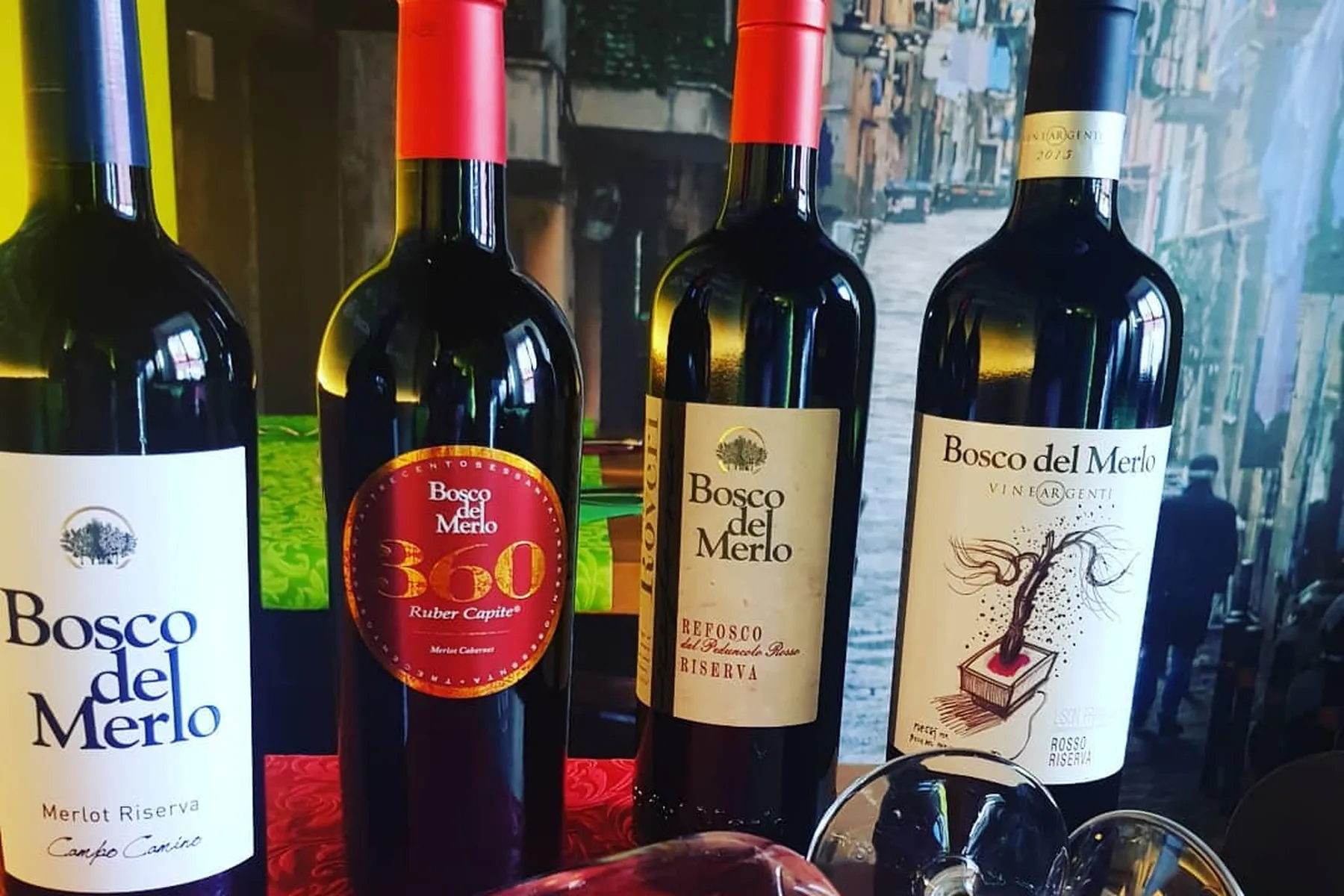 Rotweine von Bosco del Merlo auf rotem Tischtuch
